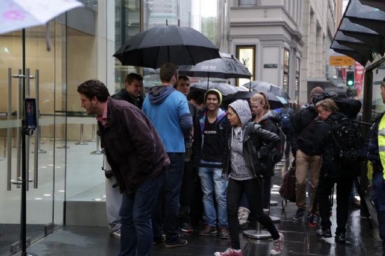 호주 시드니 애플 스토어 앞에서 우산을 들고 기다리는 사람들. (사진=씨넷_