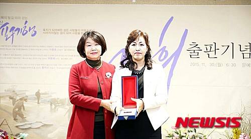 【울산=뉴시스】구미현 기자 = 울산지역 언론인 출신 수필가 고은희씨가 최근 울산지역 포구의 사진과 이야기를 담은 책 '고은희의 발길 따라 걷는 울산 포구기행' 발간하고 출판기념회를 열었다고 9일 밝혔다. 지난달 30일 울산문화예술회관에서 열린 출판기념회에서 고은희씨가 에세이울산문학회 전 회장으로부터 공로상을 수상하고 기념촬영을 하고 있다. 2015.12.09. (사진=에세이울산문학회 제공) photo@newsis.com