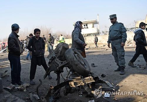 28일 아프가니스탄 수도 카불 공항 부근에서 경찰과 주민이 탈레반의 자폭 테러 현장을 살펴보고 있다.(AFP=연합뉴스)
