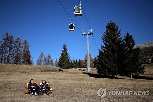 스키 대신 일광욕. 눈이 내리지 않은 이탈리아 한 스키장 슬로프에서 31일(현지시간) 남녀가 햇빛을 쬐고 있다.(AFP=연합뉴스)