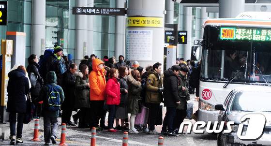 제주를 찾은 관광객들이 제주국제공항 내 버스정류장에서 버스를 타기위해 줄지어 서 있다.뉴스1 © News1 이석형 기자