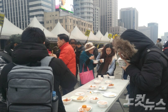 서울 광화문 광장에서 봉사단체 '밥차' 회원들이 세월호 유족과 시민들에게 떡국 등 음식을 나눠주고 있다. (사진=강혜인 수습기자)