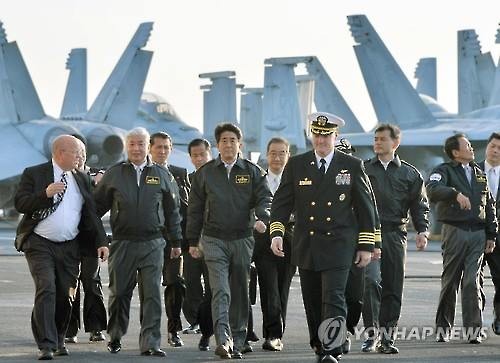 아베 신조(安倍晋三, 앞줄 왼쪽 세 번째) 일본 총리와 나카타니 겐(中谷元, 앞줄 왼쪽 두 번째) 일본 방위상이 2015년 10월 18일 오후 일본 가나가와(神奈川)현 앞바다 사가미(相模)만에서 미국 원자력 항공모함 로널드 레이건호에 탑승해 미군 측의 안내를 받고 있다.[교도=연합뉴스] (끝)