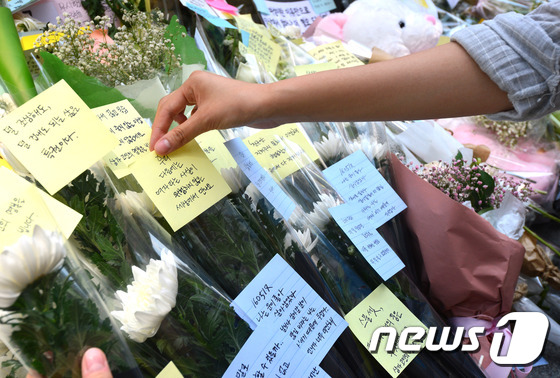 서울 강남역 10번 출구 앞에서 시민들이 '강남 묻지마 살인사건'의 20대 여성 희생자 추모 메시지를 적은 포스트잇을 붙이고 있다. /뉴스1 © News1 최현규 기자