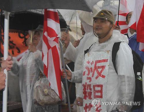 일본군 모자를 쓴 혐한 시위 참가자가 '반일 분자를 쳐죽여라'라고 쓴 종이 피켓을 목에 걸고 있는 모습. [연합뉴스 자료사진]