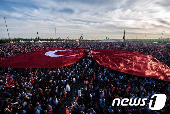 터키 시민들이 거대한 국기를 들고 레제프 타이이안 에르도안 대통령의 연설을 듣고 있다. © AFP=뉴스1 © News1