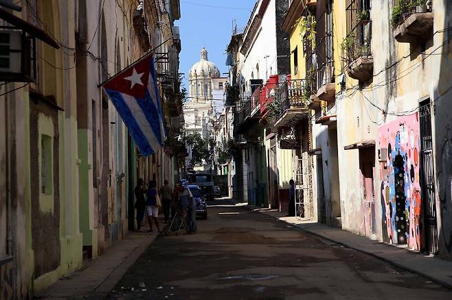 올드 아바나의 골목, 쿠바 국기 너머 혁명박물관이 보인다.