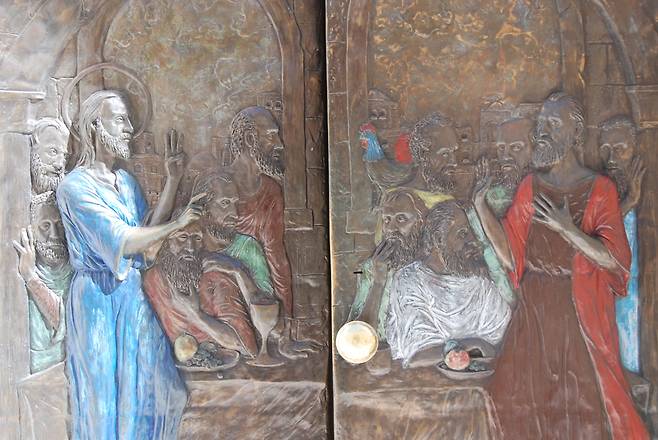 예루살렘 성 밖에 있는 베드로 통곡교회의 문. 닭 울기 전 세 번이나 자신을 부인할 것이라 예언하는 예수와 손을 젓는 베드로가 새겨져 있다.