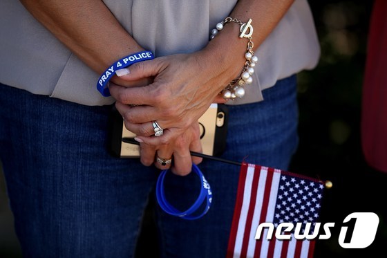 한 시민이 미국 텍사스 주 댈러스에서 발생한 백인 경관 저격 사건을 추모하고 있다. © AFP=뉴스1