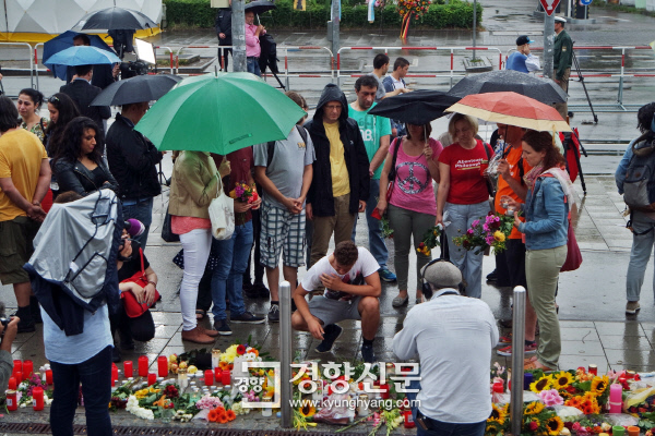 올림피아 쇼핑센터 앞에 마련된 추모소에 23일 시민들이 빗속에서도 꽃다발과 양초들을 놓으며 희생자들을 기리고 있다. 뮌헨|정동식 통신원