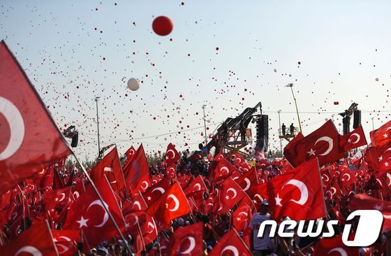 터키 이스탄불서 열린 지난달의 실패한 쿠데타에 반대하는 집회에서 레제프 타이이프 에르도안 대통령 지지자들이 거대한 스크린 앞에서 국기를 흔들며 열광하고 있다.© AFP=뉴스1
