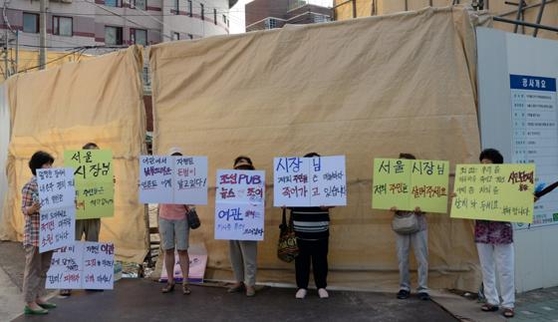 무악2구역재개발조합 조합원들이 공사현장 앞에서 피켓을 들고 박원순 서울시장을 규탄하고 있다. /고성민 기자