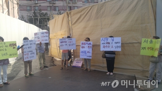 22일 오전 철거가 재개된 서울 종로구 무악2구역 공사 현장 앞에서 조합원들이 공사를 진행하겠다는 내용의 피켓을 들고 서 있다. /사진=김사무엘 기자