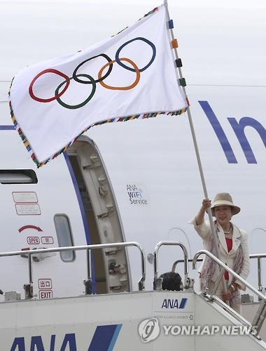 올림픽 깃발을 흔드는 고이케 도쿄도지사