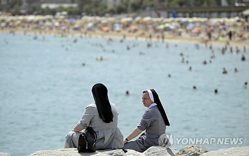 부르키니 금지로 프랑스에서 따로 주목받는 해변 방문하는 수녀들.사진은 스페인 바르셀로나의 풍경.[AP=연합뉴스 자료사진]