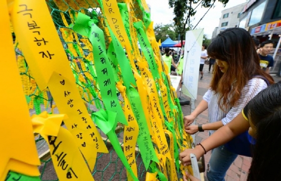 28일 오후 서울 마포구 서교동 홍대 걷고 싶은 거리에서 열린 '2016 잔다리마을 문화축제'에서 시민들이 젠트리피케이션 극복 의지를 적은 리본을 달고 있다.<br /><br>