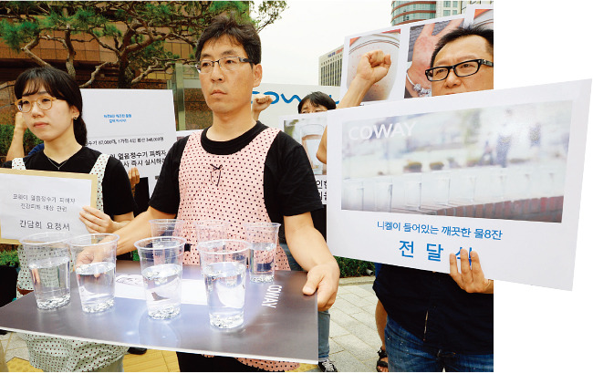 8월 24일 서울 중구 코웨이 본사 앞에서 환경운동연합 회원들이 중금속 배출 문제에 항의하는 퍼포먼스를 하고 있다. [뉴스1]