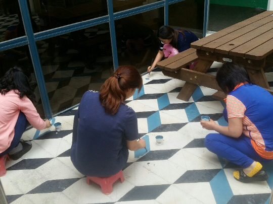 전남 보성군 다향고등학교의 벽화 그리기 봉사활동 동아리 학생들과 교사들이 2015년 6월 다향고 바닥에 페인트칠을 하고 있다.  다향고 제공