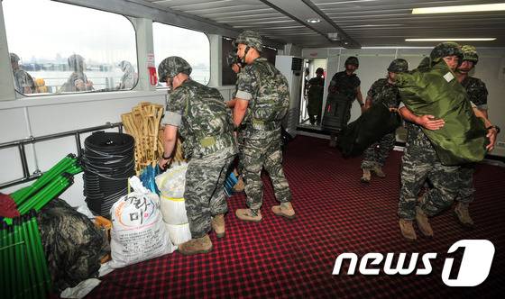 국가 신속기동부대인 해병대 대원들이 완전무장으로 울릉도 복구 작업애 사용할 복구장비를 정기여겍선인 썬플라워호에 선적하고 있다...2016.9.2/뉴스1 © News1 최창호 기자