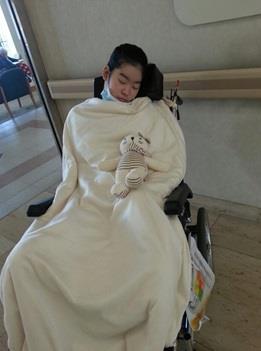 (수원=연합뉴스) 지난 3월 경기 성남 소재 병원에서 치료받고 있는 박채원(17)양이 휠체어에 앉아 잠들어 있는 모습. [초록우산어린이재단 제공 = 연합뉴스]