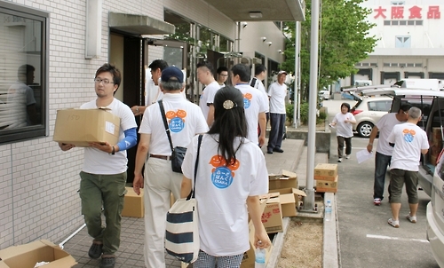 [사카이<일 오사카부> 교도=연합뉴스 자료사진] 오사카부 사카이시에 있는 오사카식품유통센터에 있는 재고식품을 아동양호시설 등지에 배급해주기 위해 식품을 나르는 자원봉사자들.