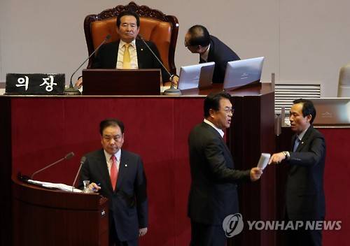 새누리당 이우현 의원(단상 아래 왼쪽)이 '짧은 질문, 긴 답변'으로 일관하는데 대해 더불어민주당 의원들의 항의가 잇따르자 정진석 원내대표(단상 아래 가운데)가 정세균 의장에게 항의하고 있다. 오른쪽은 맞대응하러 나온 더불어민주당 우상호 원내대표.