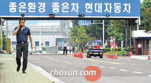 현대자동차 노동조합이 12년 만에 전면파업에 들어간 26일, 현대차의 울산과 전주, 아산공장의 모든 생산 라인이 멈췄다. 노조 조합원들은 출근하지 않고 부서별로 단합대회를 가졌다. 이날 오후 오가는 차량이 거의 없는 울산시 북구 현대차 명촌정문 앞을 한 시민이 지나고 있다. /김종호 기자