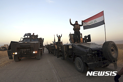 【모술=AP/뉴시스】이라크 정예 대테러 부대가 20일(현지시간) 이슬람국가(IS)가 점령하고 있는 모술을 향해 진격하면서 이라크 국기를 펼쳐보이고 있다. 2016.10.20
