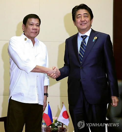 아베 신조 일본 총리(오른쪽)와 로드리고 두테르테 필리핀 대통령이 지난 9월 동남아시아국가연합 정상회의가 열린 라오스 비엔티안에서 정상회담 중 악수를 하고 있다. [EPA=연합뉴스 자료사진]