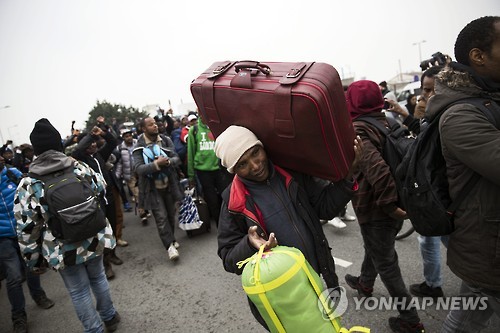 24일(현지시간) 짐을 꾸려 프랑스 칼레 난민촌을 떠나는 사람들 [EPA=연합뉴스]