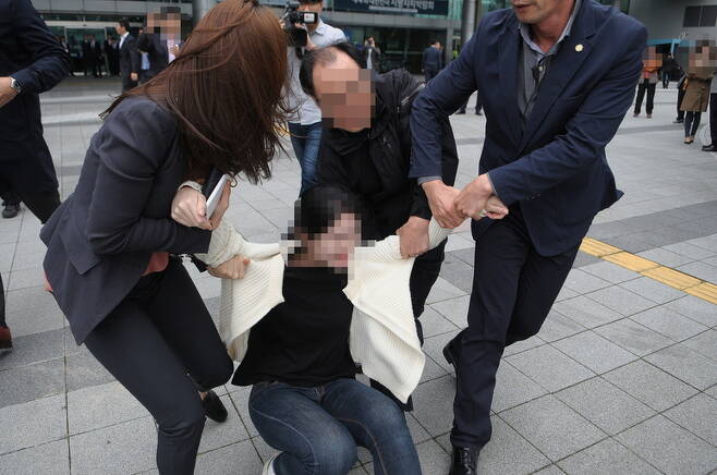27일 부산 해운대구 벡스코 제2전시장에서 열린 행사에 참여한 박근혜 대통령의 하야를 촉구했던 한 대학생이 경호원 등에게 끌려나가고 있다. <민중의소리> 제공