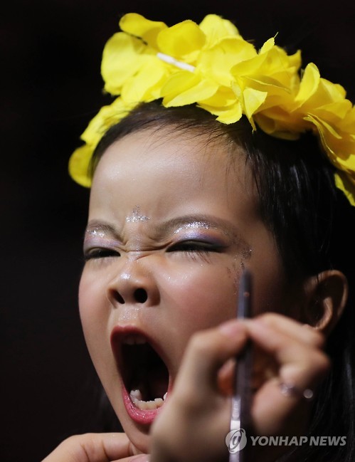 참가한 중국 소녀가 분장도중 하품하고 있다[연합뉴스 자료사진]
