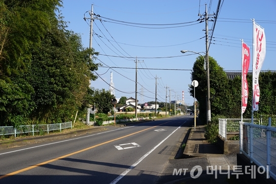 지난달 21일 찾은 일본 이바라키현 나카군 도카이무라 거리에 행인이 없어 한적한 모습이다. 멀리 보이는 굴뚝이 도카이 원전 1호기의 모습. / 사진=이동우 기자