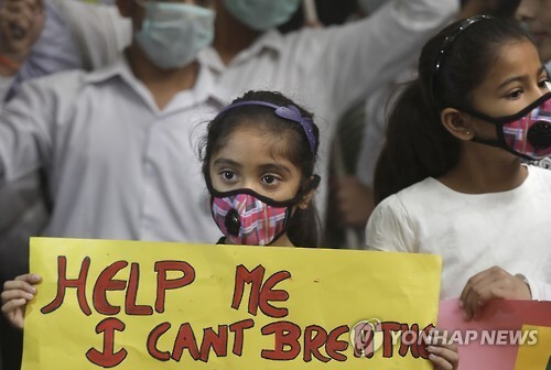 6일 인도 수도 뉴델리에서 학생들이 대기오염을 막아달라는 글을 들고 있다.[AP=연합뉴스 자료사진]