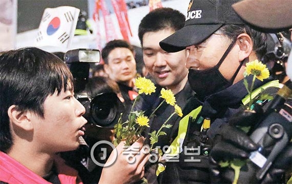 청와대 입구인 서울 내자동에서 한 학생이 경찰에게 꽃을 건네고 있다. [사진 박종근 기자]
