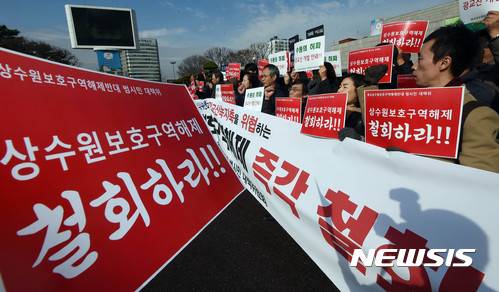 【수원=뉴시스】 이정선 기자 = 30일 오전 경기 수원시청에서 열린 광교 상수원 보호구역 해제 철회 촉구 기자회견에서 광교상수원보호구역해제반대 범시민 대책위 회원들이 구호를 외치고 있다. 2016.11.30. ppljs@newsis.com