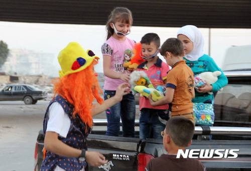 【AP/뉴시스】 = 시리아의 자원봉사자 아나스 알-바샤(24)가 생전에 어릿광대로 분장한 채 알레포의 어린이들에게 장난감을 나눠주고 웃겨주던 모습.  그는 11월 29일 정부군과 러시아군의 미사일 공격으로 폭사했다.