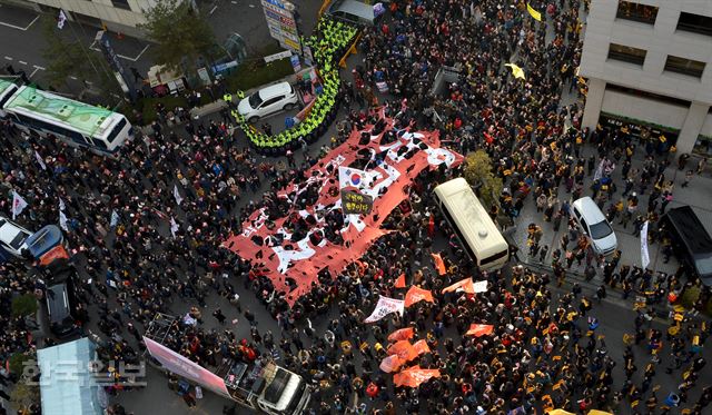 3일 서울 여의도 새누리당사 앞에서 집회를 갖은 시민들이 새누리당 깃발을 찢는 퍼포먼스를 하고 있다. 김주성 기자