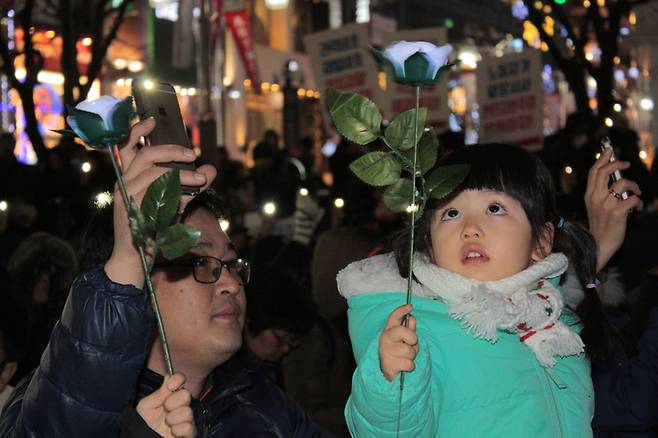 10일 저녁 대구 중구 국채보상로에서 열린 ‘박근혜 퇴진 6차 대구시국대회’에서 한 아버지와 딸이 불이 켜지는 꽃 모양의 ‘촛불’을 들고 있다. 김일우 기자 cooly@hani.co.kr