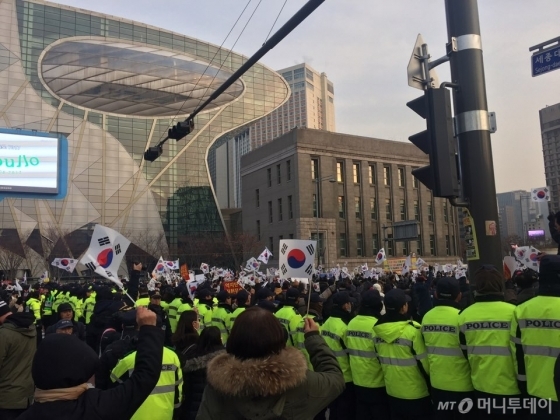 경찰이 박근혜 대통령 탄핵 반대를 외치는 보수단체의 맞불집회와 퇴진을 요구하는 9차 촛불집회 참가자의 충돌을 막기 위해 인간 띠를 만들었다. /사진=방윤영 기자