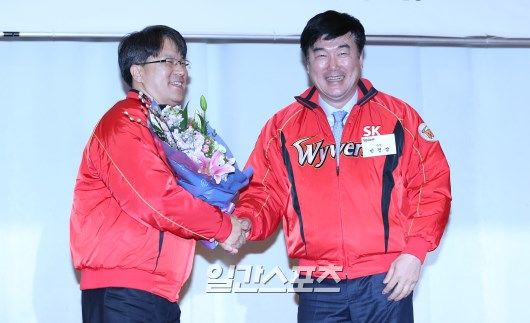 2016년 1월 구단 시무식에서 류준열 대표이사에게 꽃다발을 전달하고 있는 민경삼(오른쪽) 전 SK 단장. 양광삼 기자