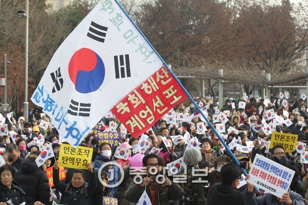 박근혜 대통령 탄핵에 반대하는 보수단체 집회 참가자들이 `계엄령 선포`라고 적힌 깃발을 흔들고 있다. [중앙포토]