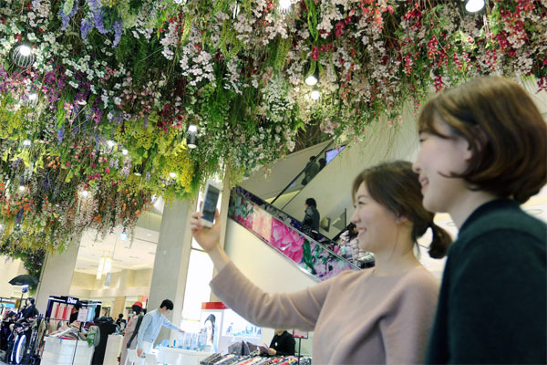 신세계백화점에서는 신세계판 포켓몬고 게임이 가능하다. 고객들이 스마트폰으로 나비를 잡을 수 있는 `봄나비 잡기(Butterfly Catch)` 게임을 즐기고 있다. [사진 제공 = 신세계백화점]