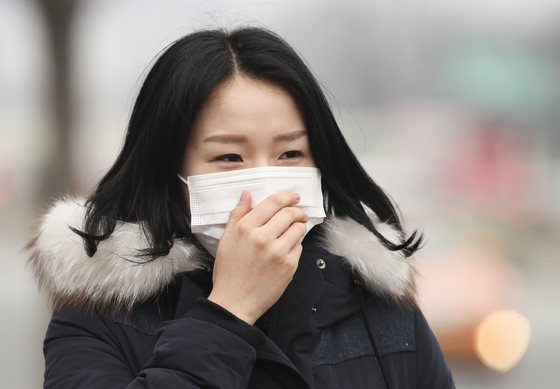 중국발 스모그가 유입되며 미세먼지 나쁨 수준을 보인 27일 광화문에서 한 시민이 마스크를 착용하고 길을 걷고 있다.