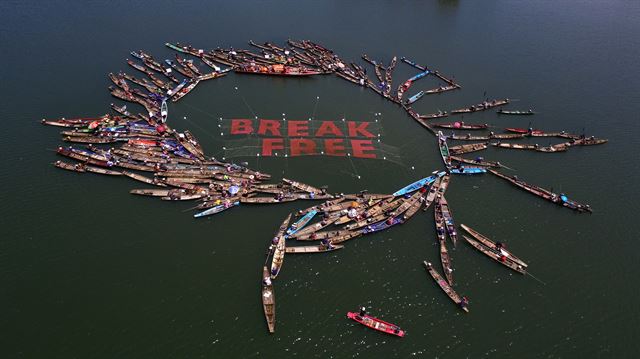 지난달 17일 태국을 동서로 관통하는 문강 주변 50여개 부락 어민들이 200여척의 어선을 타고 '화석연료로부터 탈출하라' 라는 구호를 그물로 감싸고 선상시위를 하고 있다. 그린피스 제공