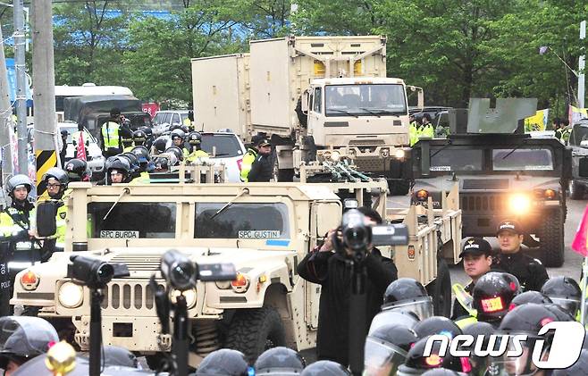26일 오전 경북 성주골프장으로 사드(THAAD·고고도미사일방어체계) 장비를 실은 트레일러가 경찰 통제 속에 들어가고 있다. 골프장 입구에서는 이에 반대하는 주민들과 경찰이 대치하고 있다. 2017.4.26/뉴스1 © News1 이종현 기자
