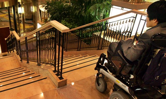 휠체어를 탄 한 장애인이 서울의 한 건물 계단에서 내려가지 못하고 멈춰 서 있다. /조선일보 DB