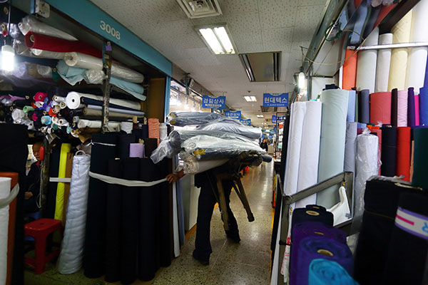 ⓒ윤성희 4월12일 서울 동대문종합시장에서 한 지게꾼이 원단을 짊어지고 운반하고 있다.