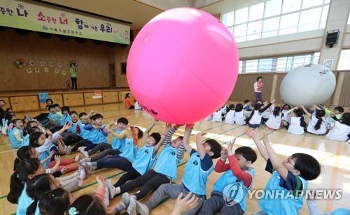 (서울=연합뉴스) 이정훈 기자 = 1일 오전 서울 서초구 우솔초등학교 학생들이 미세먼지로 인해 실내에서 열린 체육대회에서 공 넘기기 게임을 하고 있다. 2017.5.1 uwg806@yna.co.kr