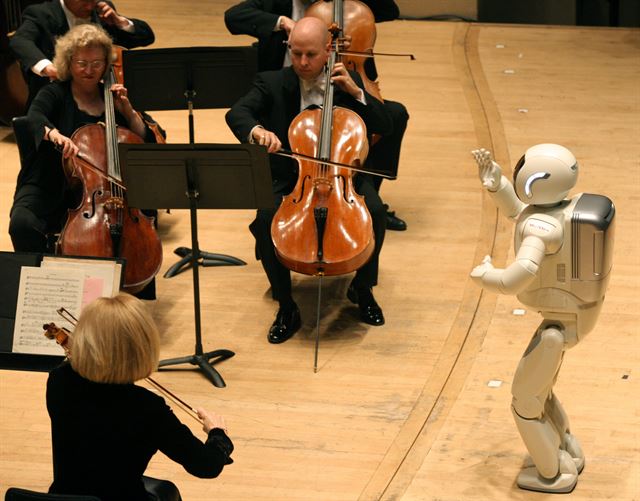 휴머노이드 아시모가 2008년 5월 미 디트로이트 심포니 오케스트라를 지휘하고 있다. 연주는 첼리스트 요요마와 협연으로 이뤄졌으며 매진됐다.     한국일보 자료사진